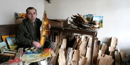 Florin Vîlcu pictează pe scoarţa de copac. Foto: Victor C. Boldîr. 