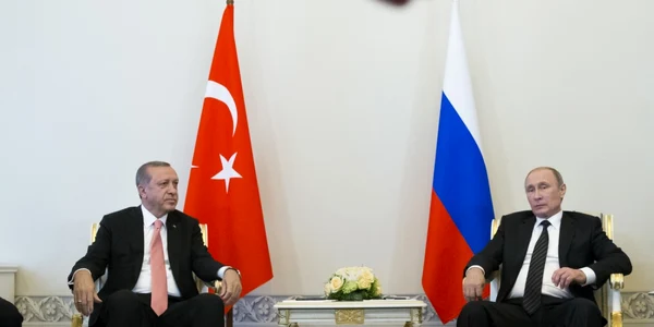 Preşedintele rus Vladimir Putin şi preşedintele turc Recep Tayyip Erdogan discută în timpul întâlnirii iar un membru al securităţii incearca sa opreasca fotografii la palatul Constantin din afara St.Petersburgului Rusia FOTO AP / Alexander Zemlianich
