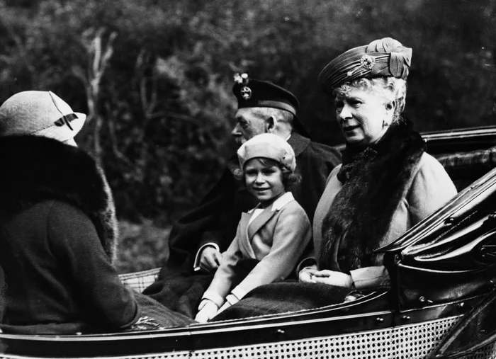 Scoţia, 1935: prinţesa Elisabeta, mai târziu regina Elisabeta a II-a, aşezată în trăsură între bunicul ei regele George al V-lea şi bunica regina Maria FOTO Getty Images/ Topical Press Agency