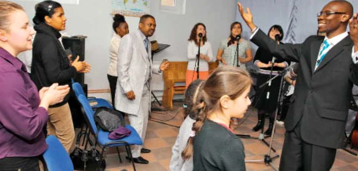 Toţi credincioşii baptişti ai bisericii din Giuleşti cântă  şi dansează alături de pastorul lor