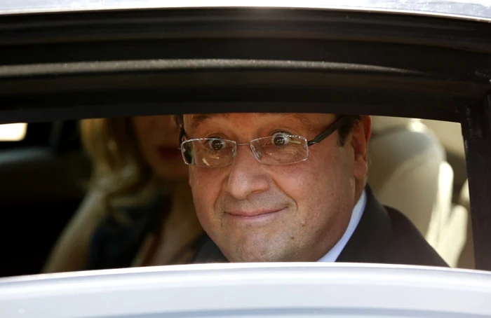 Preşedintele francez Francois Hollande, de la geamul maşinii prezidenţiale. FOTO Reuters