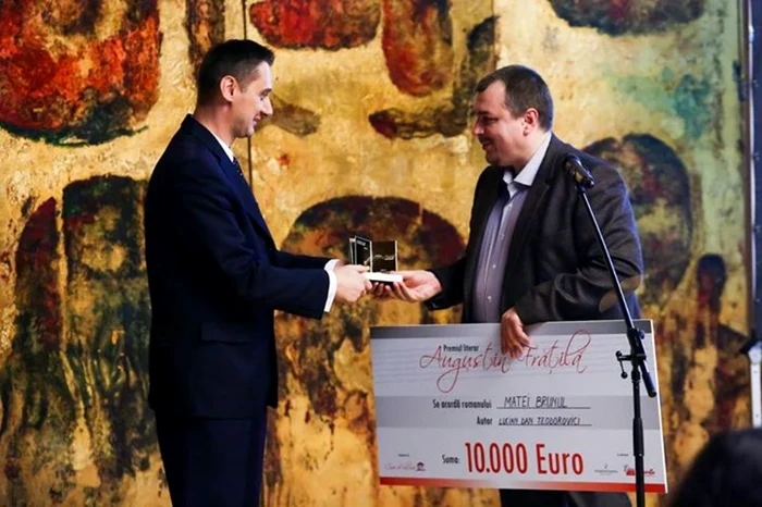 Mario De Mezzo, preşedintele Asociaţiei Casa de Cultură, oferind trofeul câştigătorului de anul trecut, Lucian Dan Teodorovici, pentru romanul „Matei Brunul“ FOTO pagina de facebook acadecu