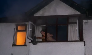 În plină acţiune, la una  dintre ferestrele casei  cuprinse de foc  jpeg