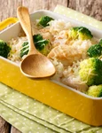 Healthy lunch: rice with broccoli, chicken, garlic and cheese close up in a baking dish on a table  horizontal jpeg