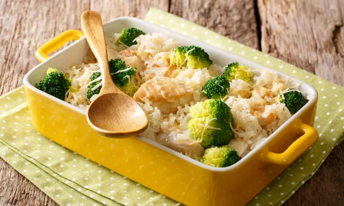 Healthy lunch: rice with broccoli, chicken, garlic and cheese close up in a baking dish on a table  horizontal jpeg