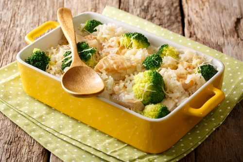 Healthy lunch: rice with broccoli, chicken, garlic and cheese close up in a baking dish on a table  horizontal jpeg