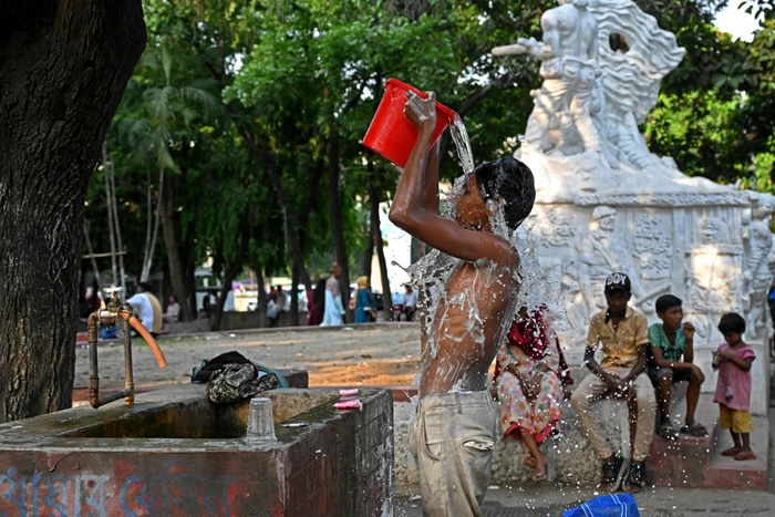 Copil făcând baie în parc, Bangladesh, aprilie 2024