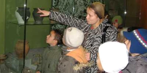 Copiii veniţi în vizită la muzeu află informaţii despre vasele de lut făcute cu sute de ani în urmă