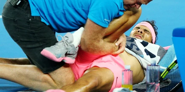 Rafael Nadal este îngrijit de antrenor după ce s-a accidentat în sfertul de finală de la Australian Open. FOTO Guliver/Gettyimages