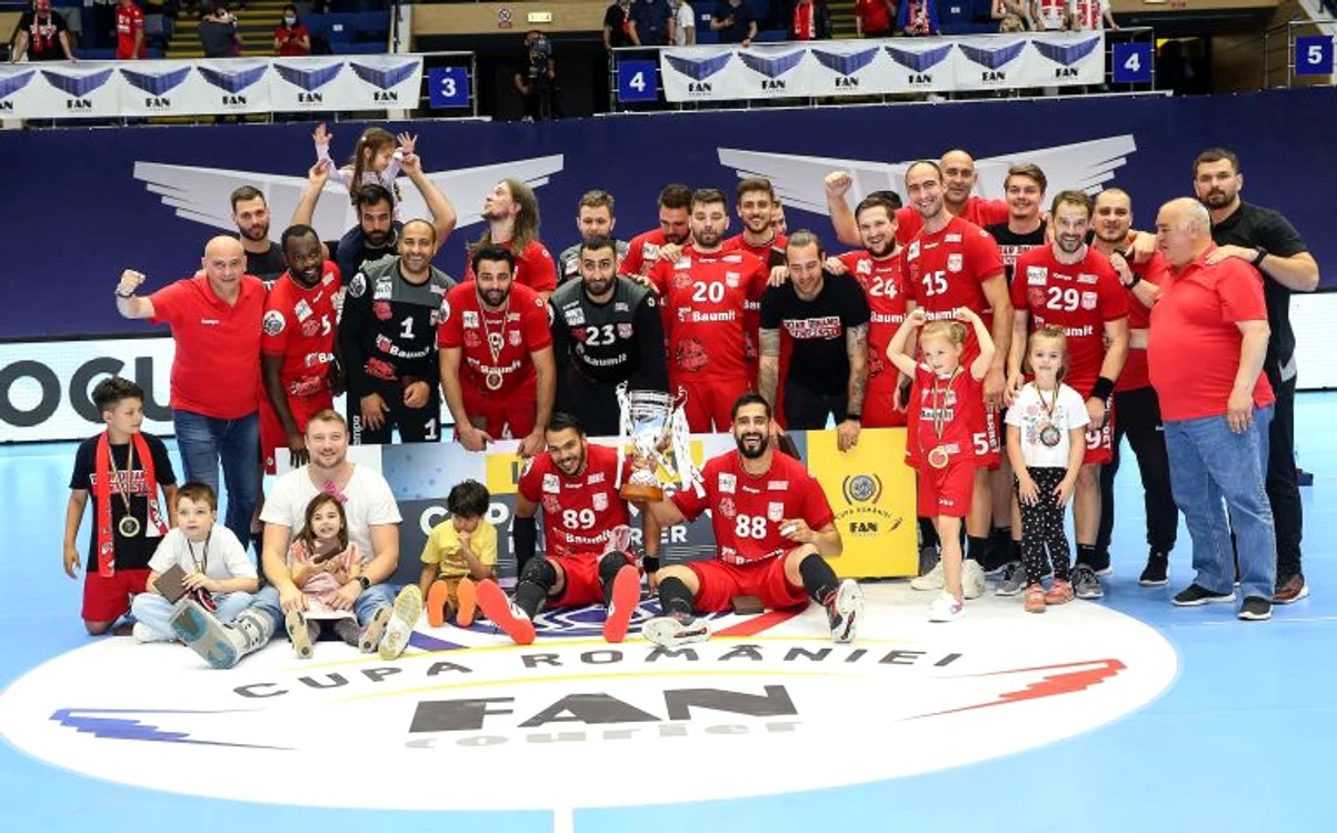 
    Cu Javier Humet printre ei, dinamoviștii au primit trofeul după succesul din finala Cupei României la handbalFOTO: Sportpictures.eu  