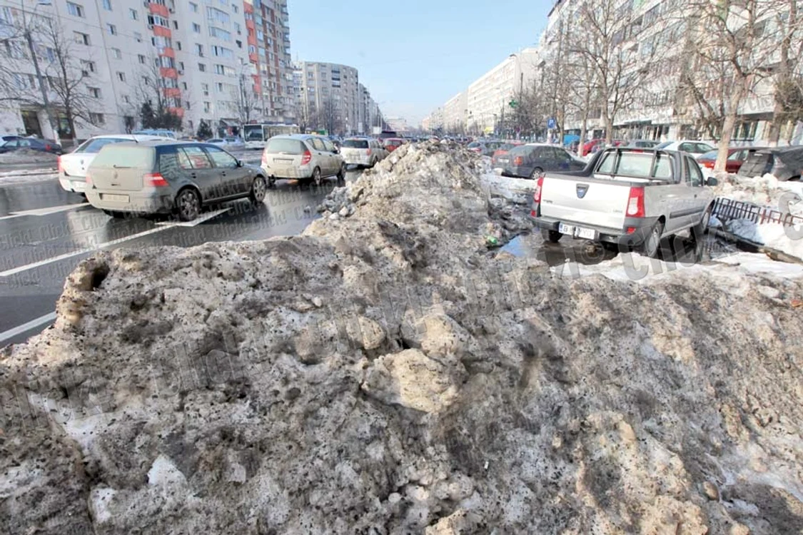 Bulevardul Ghencea: Munţii de zăpadă cu  noroi blochează de-a  valma locurile de  parcare şi trotuarele