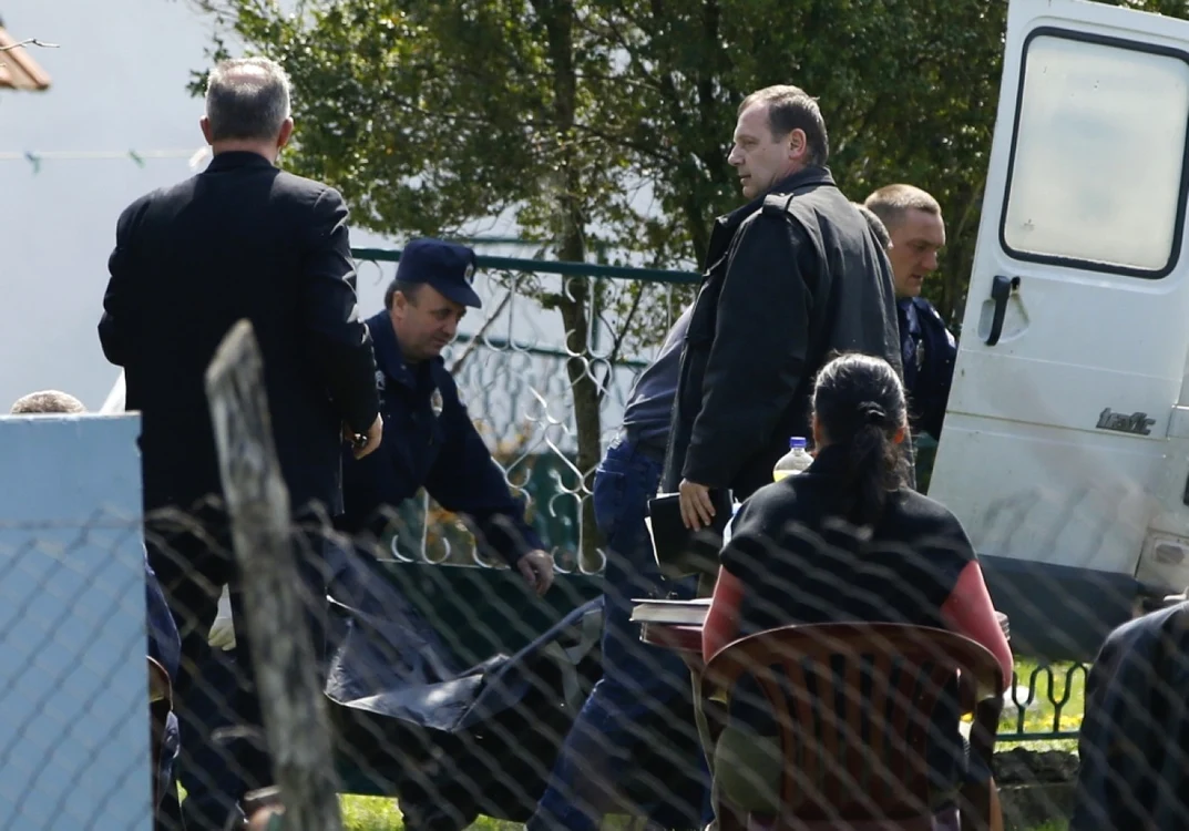 Poliţiştii ridicând cadavrul unuia dintre cele 13 victime FOTO Reuters