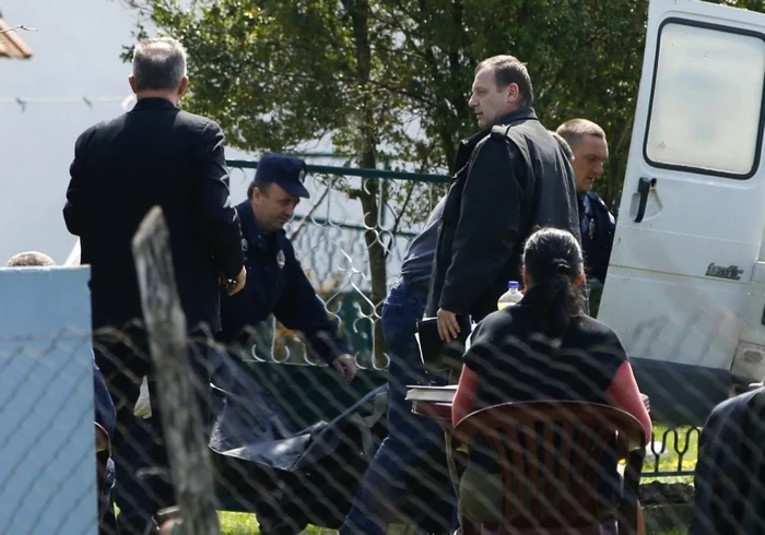 Poliţiştii ridicând cadavrul unuia dintre cele 13 victime FOTO Reuters