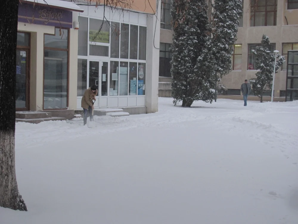 Angajaţii magazinelor înlătură zăpada cu lopeţile FOTO: adevarul