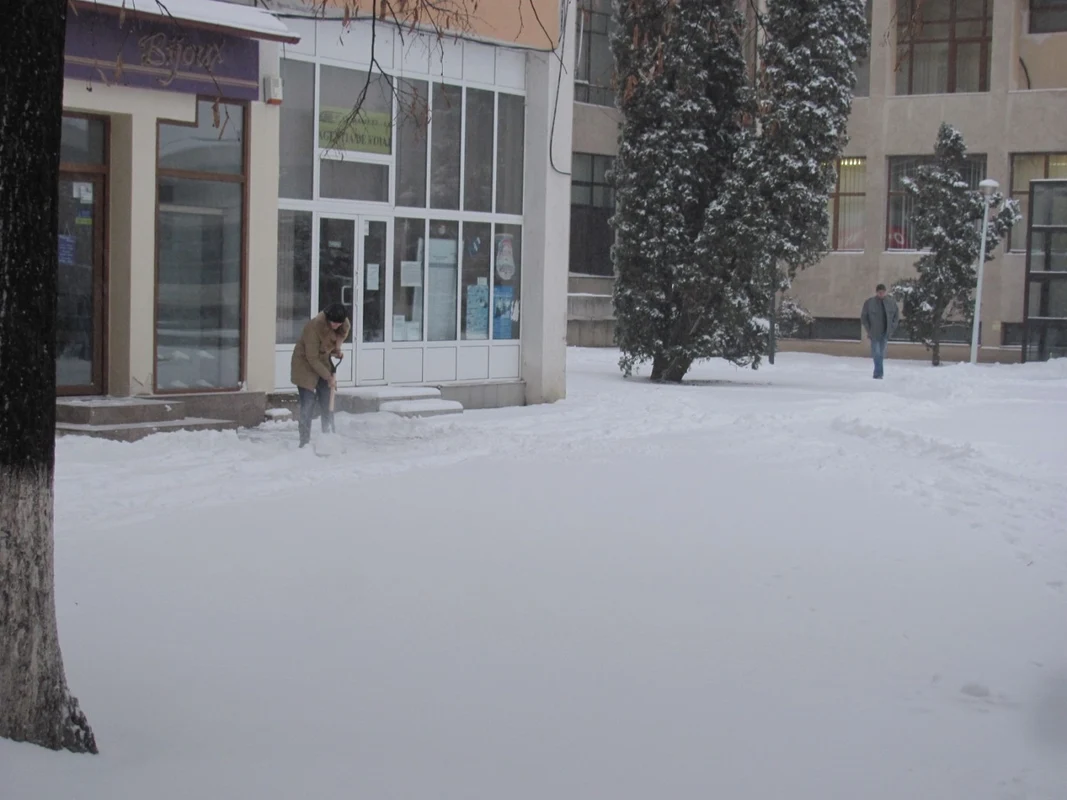 Angajaţii magazinelor înlătură zăpada cu lopata