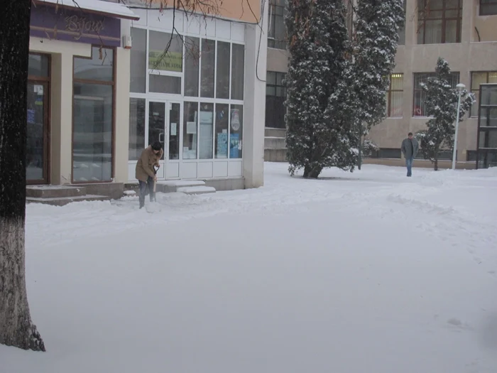 Angajaţii magazinelor înlătură zăpada cu lopeţile FOTO: adevarul