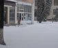 Angajaţii magazinelor înlătură zăpada cu lopata