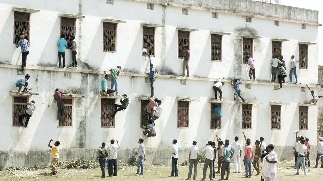 În India, în timp ce copiii dau examen, taţii stau cu fiţuica la geam