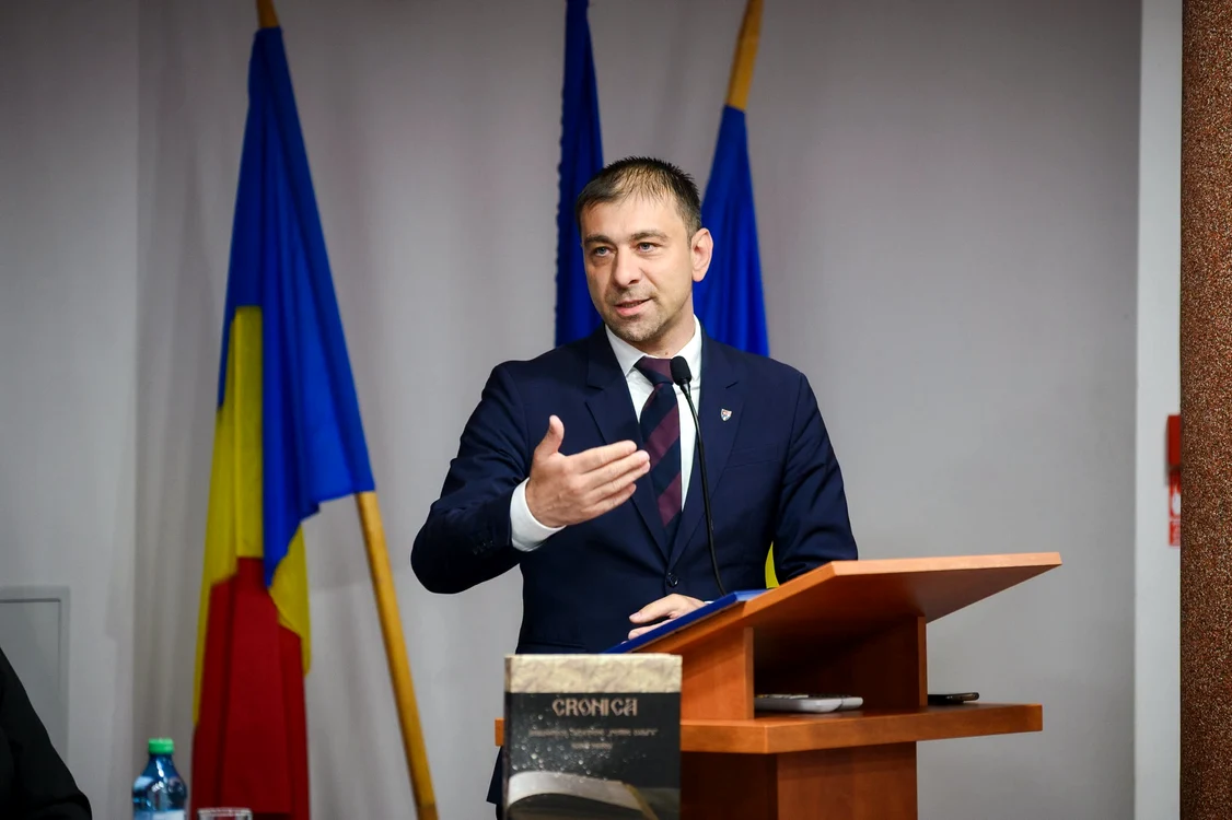 Gabriel Zetea, vicepreședintele PSD, vorbind la o conferință de presă, cu steagurile României și UE