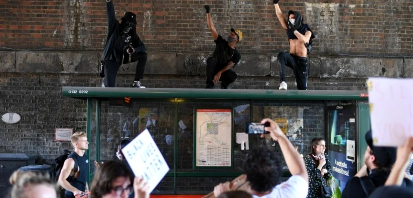 Manifestanţi protestează pe acoperişul unei staţii de autobuz în apropierea Ambasadei SUA de la Londra Foto AFP
