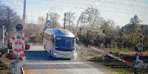 autocar filmat in timp ce forteaza trecere de cale ferata