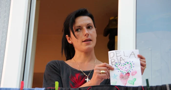 Irina Ciobanu, una dintre vecinele familiei Semenciuc, arată desenul pregătit de fiica ei pentru prietenii plecaţi în Spania