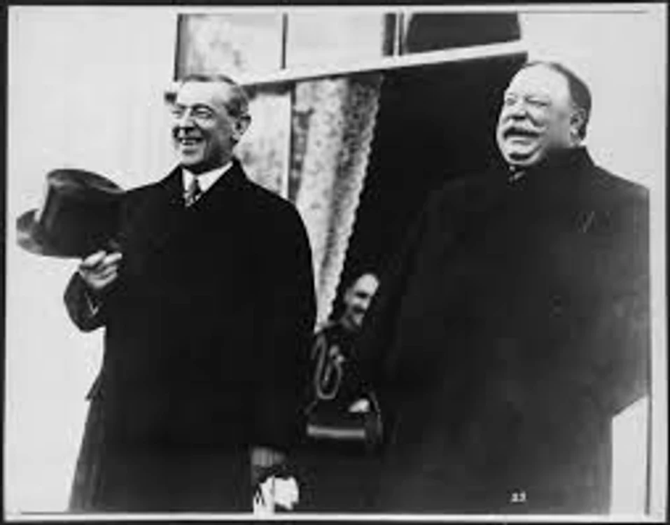 Preşedintele William Howard Taft (dreapta) îl susţine pe preşedintele Woodrow Wilson,  la ceremonia sa de învestire,  din 4 martie 1913.
