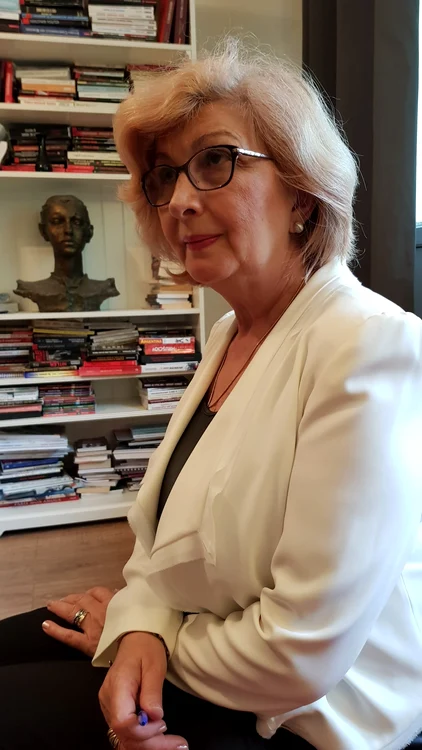 Istoricul Lavinia Betea în fața unor rafturi pline de cărți