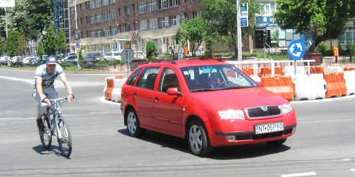 În lipsa unui spațiu special destinat deplasării, bicicliștii se strecoară printre mașini