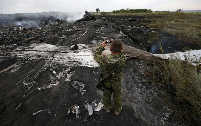 Separatist din regiunea Doneţk în faţa rămăsiţelor avionului Malaysia Airlines MH17 FOTO Reuters