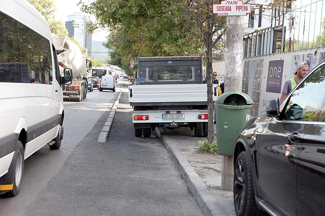 După ce trec prin staţia de autobuz şi prin intersecţie, constată că nu pot înainta din cauza maşinilor parcate
