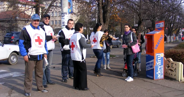 Voluntarii Crucii Roşii împart pliante pentru a încuraja donaţiile
