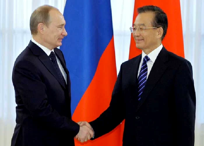 Premierul chinez Wen Jiabao dă mâna cu Vladmir Putin, într-o vizită în St. Petersburg