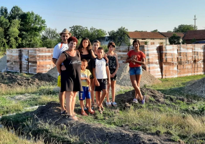 Familia Ciurescu, alături de şase din cei şapte copii luaţi în plasament, pe terenul caselor aflate în construcţie FOTO Arhivă personală