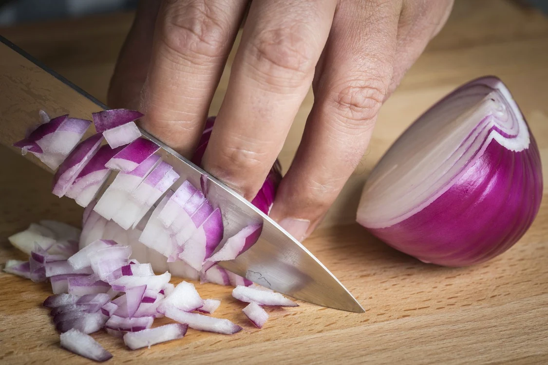 Chef choppig a red onion with a knife jpeg