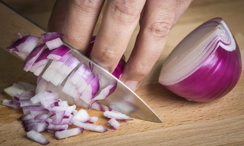Chef choppig a red onion with a knife jpeg