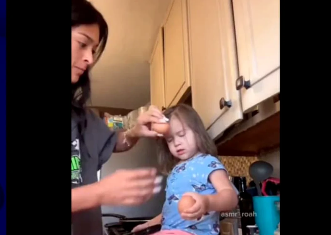Mama strivește un ou pe fruntea fiicei FOTO: captura video
