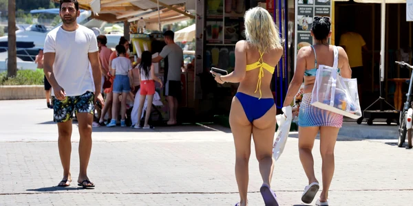 Persoane in costum de baie care se plimba pe strada FOTO Shutterstock