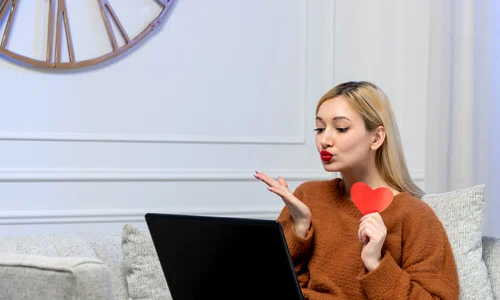 virtual love cute young blonde girl cozy sweater computer distance date holding paper heart jpg