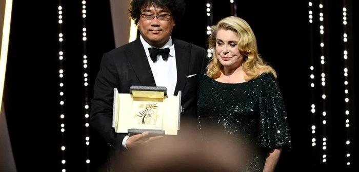 Regizorul Bong Joon Ho, alături de Catherine Deneuve, care i-a înmânat cel mai important premiu al Festivalului de Film de la Cannes / Foto Getty Images / Gareth Cattermole