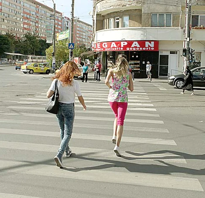 Pietonii aleargă ca să poată prinde semaforul pe verde