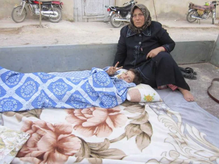 O femeie stă lângă un copil rănit în timpul unui atac armat, într-un spital improvizat din cartierul Qusser din Homs (12 septembrie) FOTO: Reuters