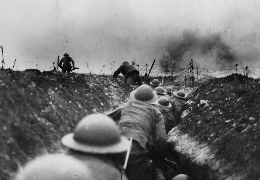 Soldaţi britanici se strecoară în tranşee printre exploziile proiectilelor germane.