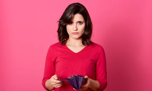 very sad adult girl with empty purse looking directly camera no money left after shopping has financial problems has no cash female being bad mood jpg