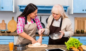cheerful senior mother helping her daughter kneading dough jpg