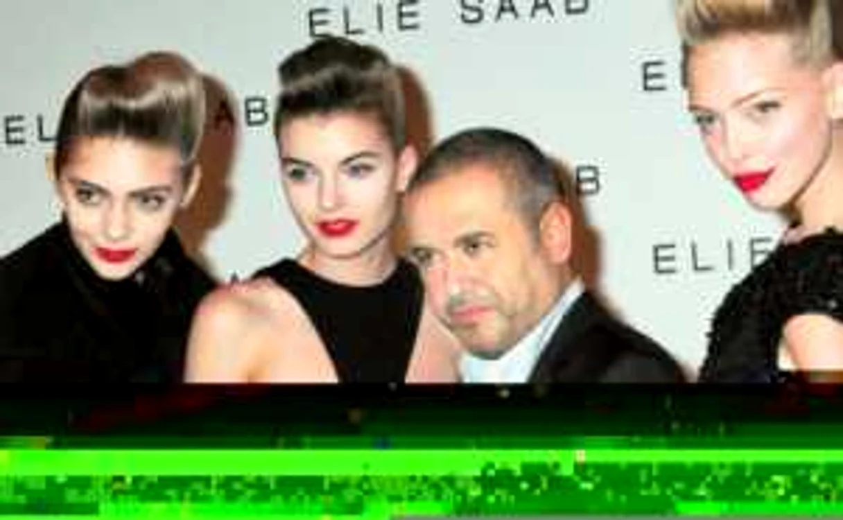 Creatorul libanez Elie Saab, înconjurat  de manechine la finalul  unei prezentări 