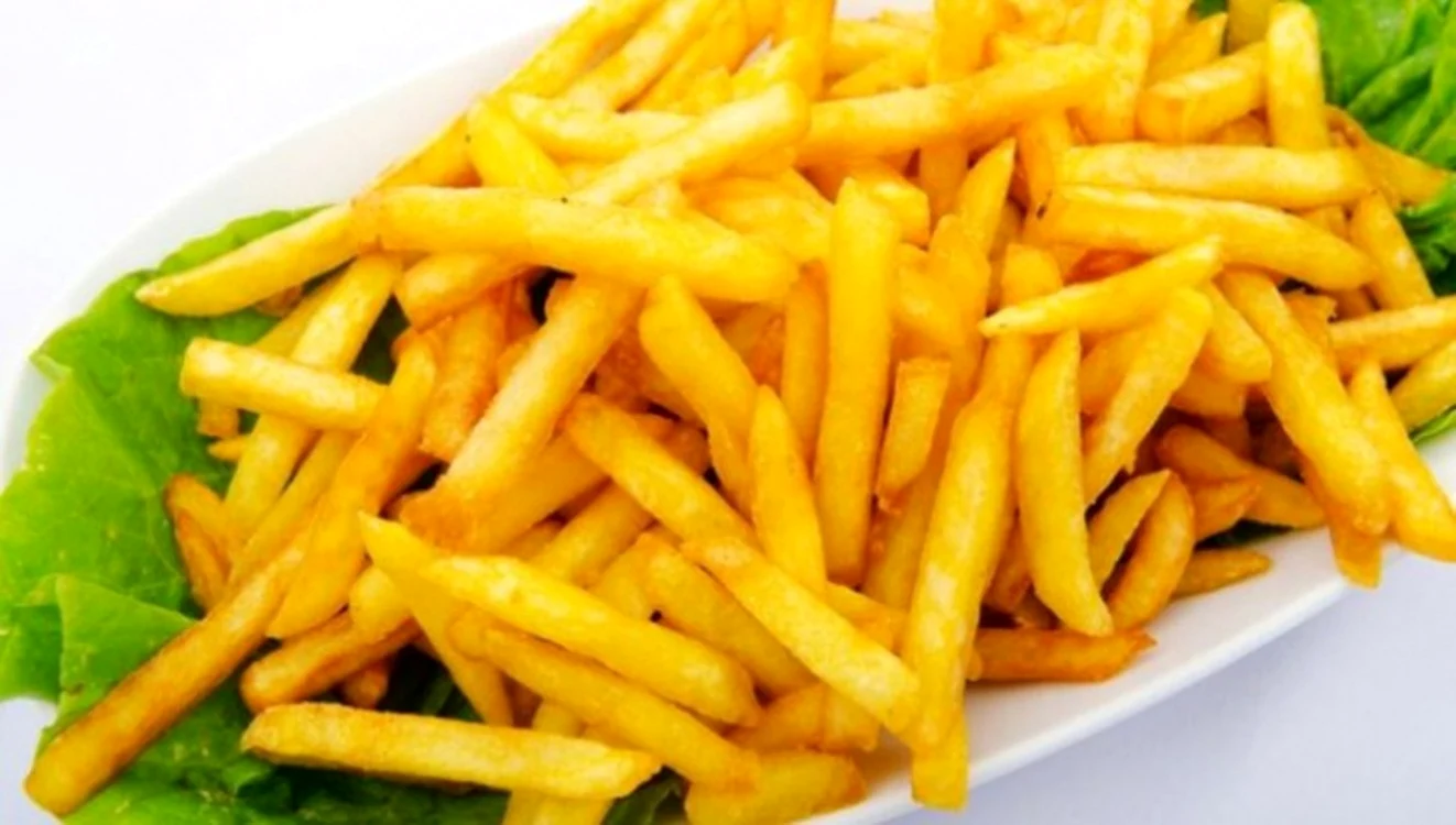 Cartofi prăjiți puți pe o frunză de salată într-o farfurie
