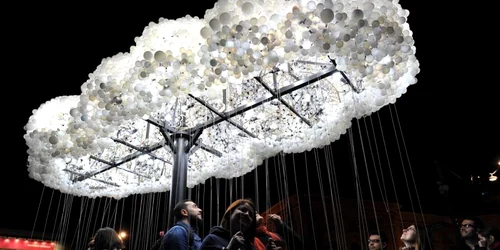 Tineri aprind si sting becuri in instalatia de arta interactiva "Cloud"