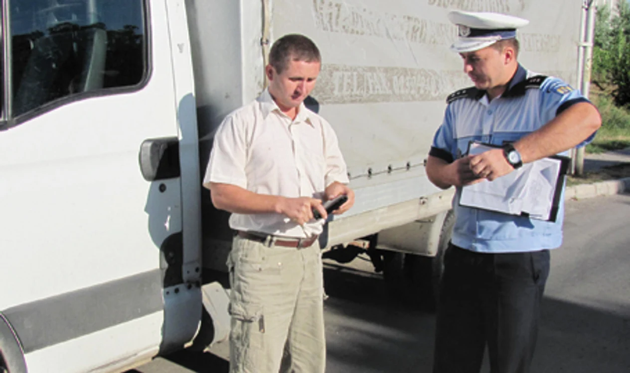 Poliţiştul verifică actele unui şofer