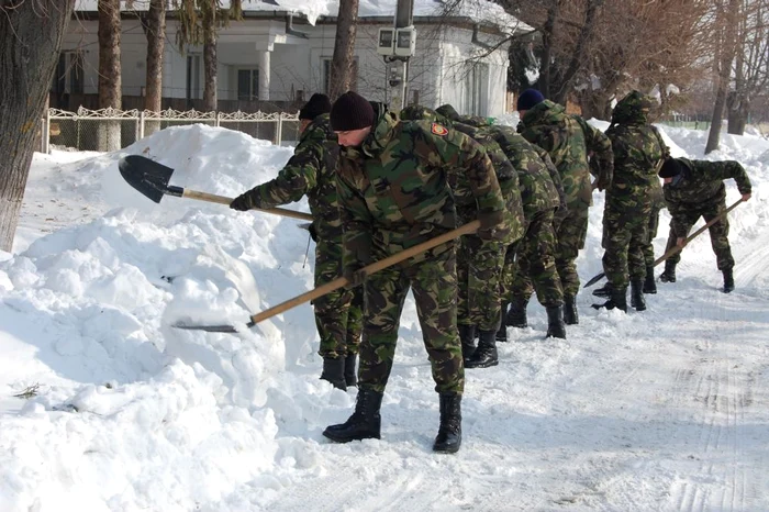 Militarii puşi la dispoziţie de MApN, în timp ce îndepărtau zăpada de pe un drum din localitatea vrânceană Dumbrăveni